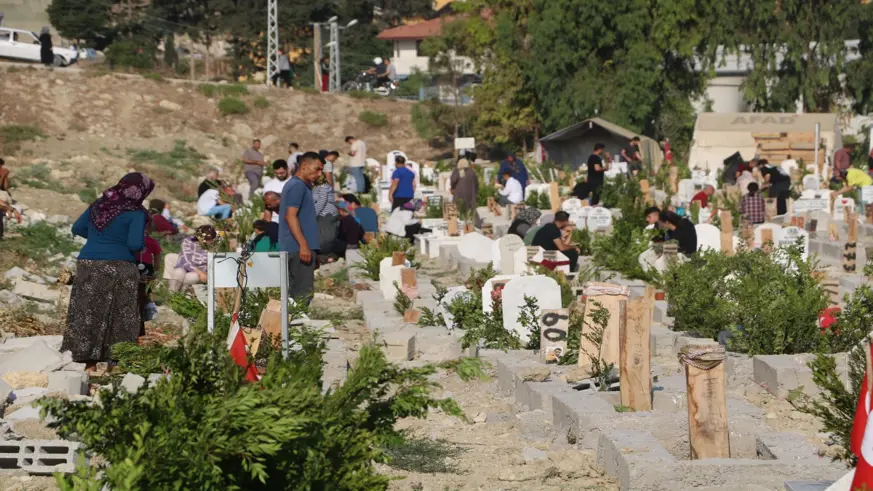 Hatay'da 3 kardeş, depremde ölen anne ve babasının mezarını ziyaret etti